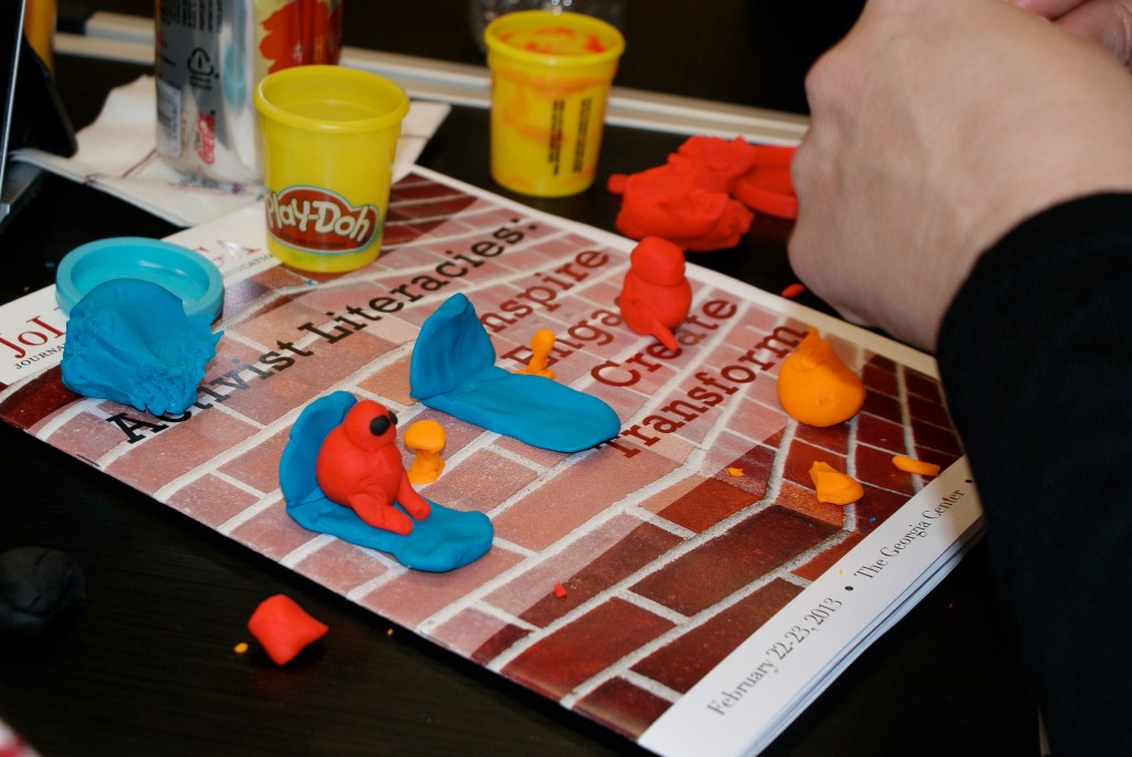 Photograph of an adult sculpting figures with playdough